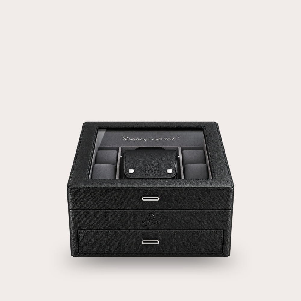 A black leather watch box with a glass top, featuring a central watch slot with a watch inside, two front drawers with silver handles, and a clean light gray background.