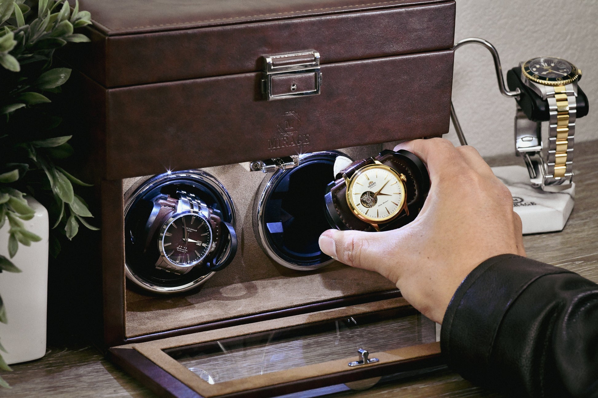 Collector placing an automatic watch into the Mirage Luxury Travel Coffee Brown luxury watch winder with adjustable pillow and ultra-quiet Mabuchi motor.