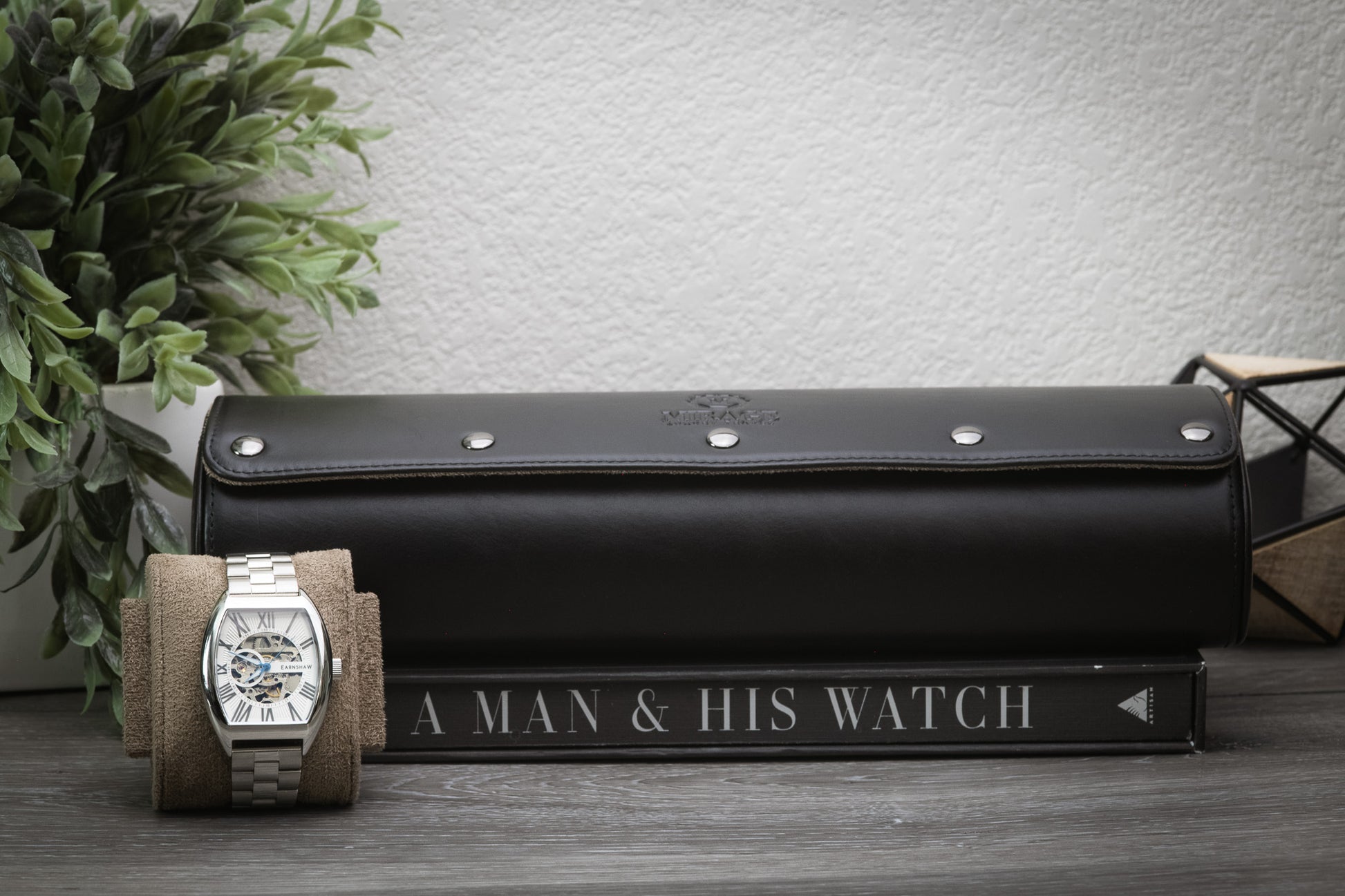 Sable black full-grain leather watch roll displayed beside a luxury watch for home organization.
