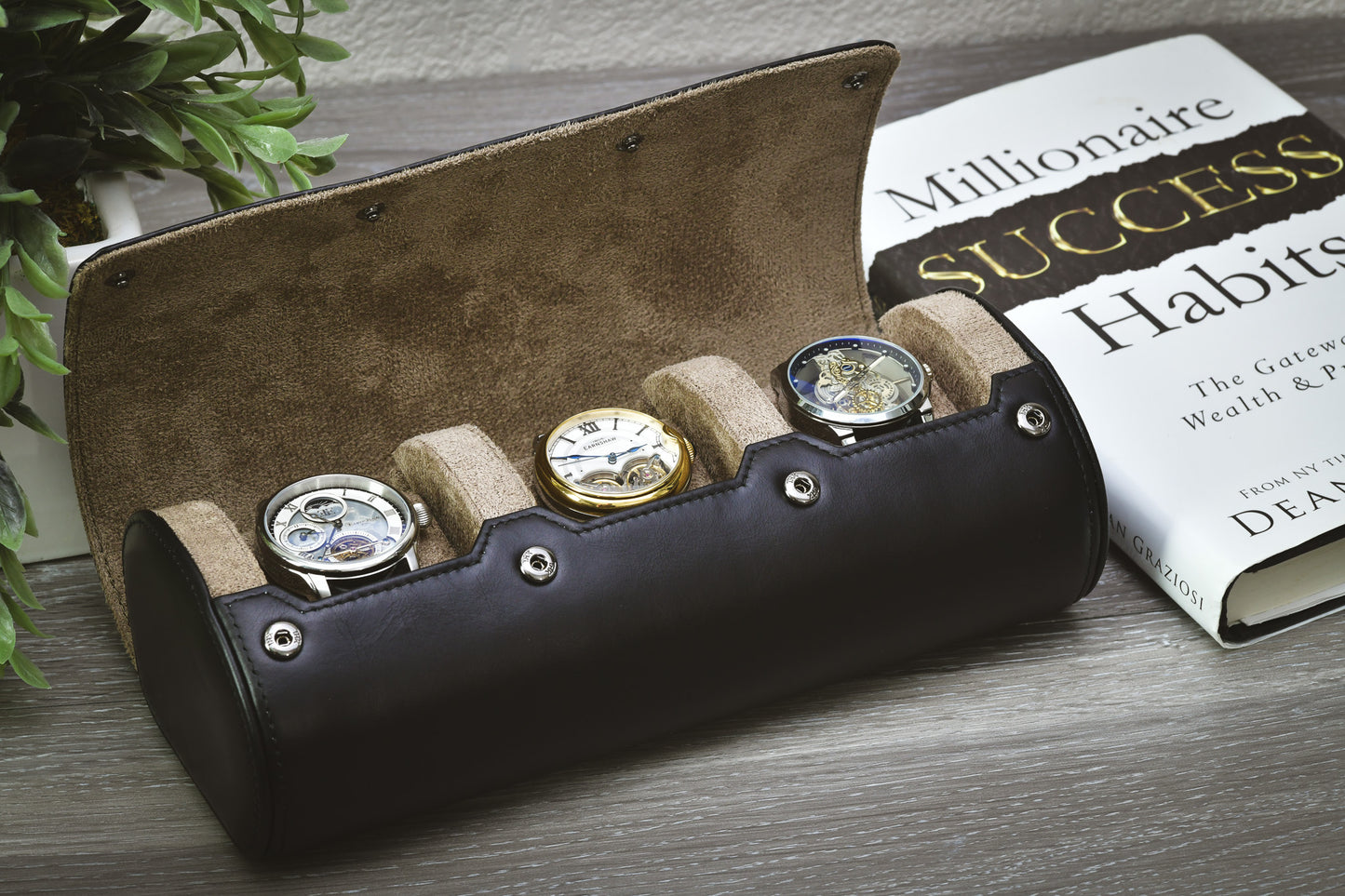 Luxury watch organizer displaying three luxury watches on a bookshelf for home storage.