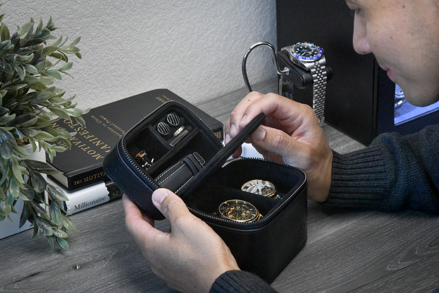 Hands opening the Obsedian Black genuine leather watch and jewelry travel case, showcasing organized storage for luxury watches and jewelry while traveling.