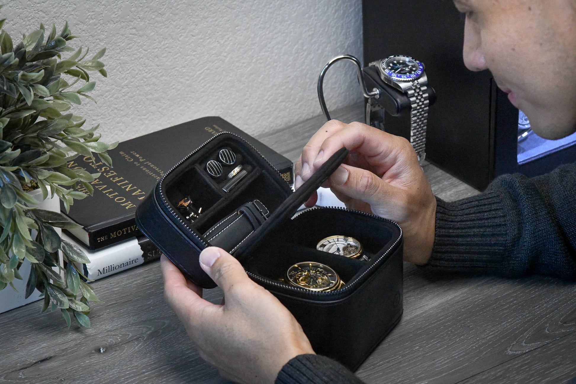 Hands opening the Obsedian Black genuine leather watch and jewelry travel case, showcasing organized storage for luxury watches and jewelry while traveling.