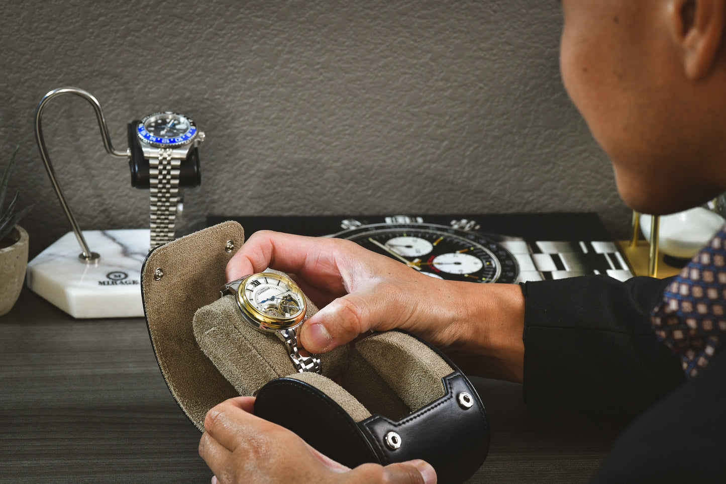 Collector placing a luxury watch into the Sable Black full-grain cow leather 1 watch roll, demonstrating secure storage and everyday protection.