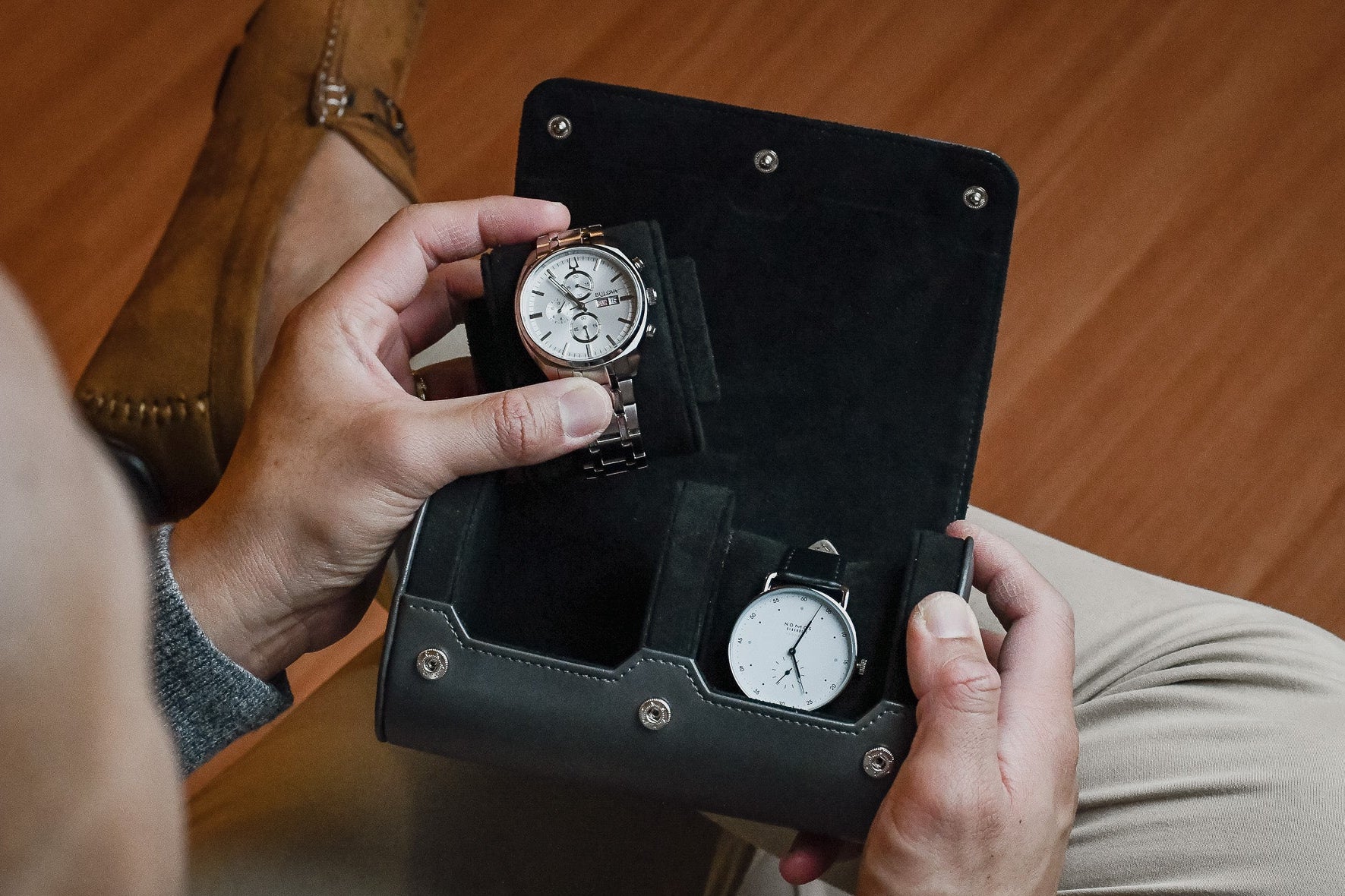 Watch collector placing a luxury timepiece inside the Slate Gray vegan leather 2 watch organizer.