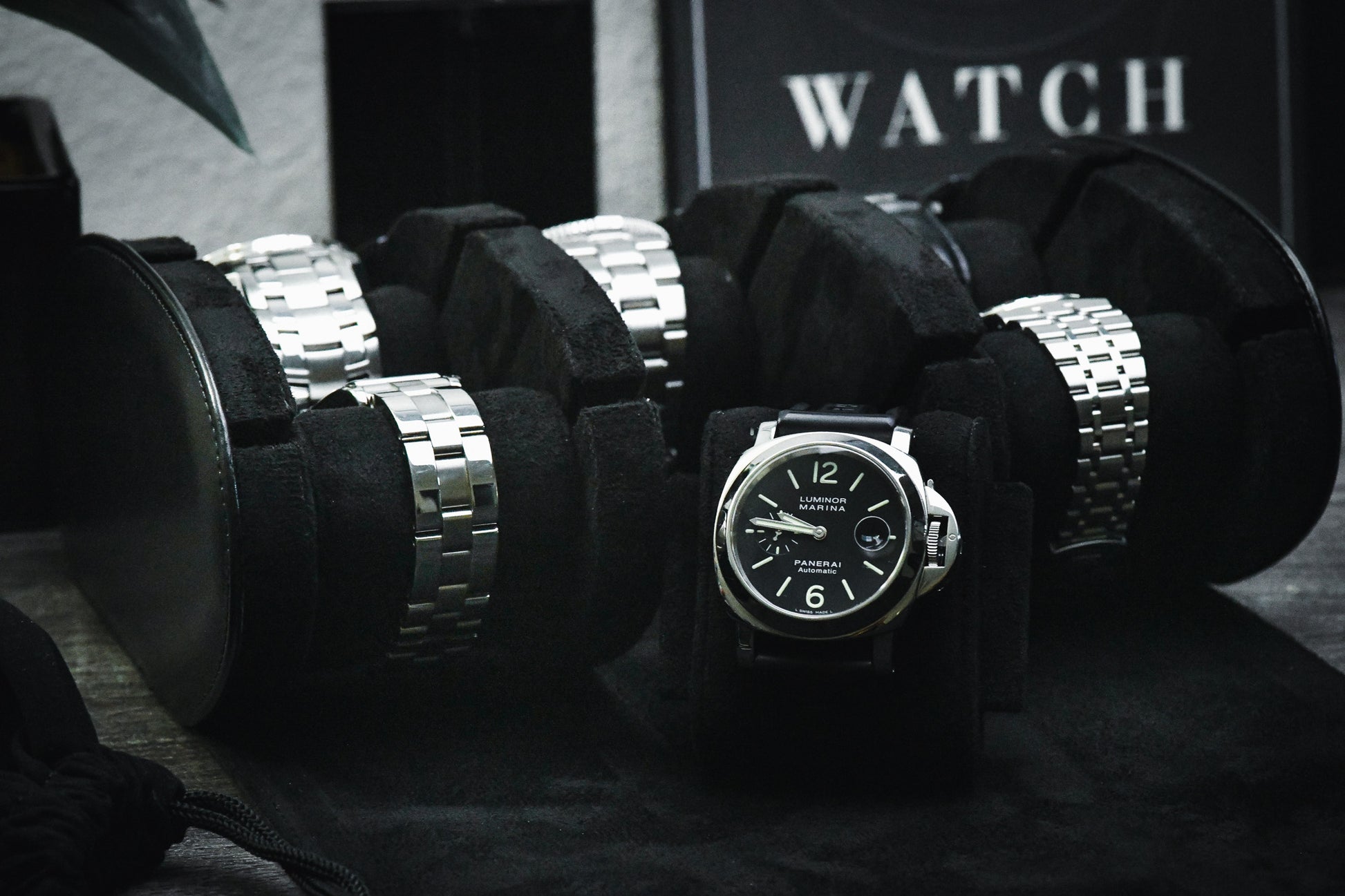 Luxury watches displayed inside Super Black premium vegan leather 6 watch roll with sliding watch cushions