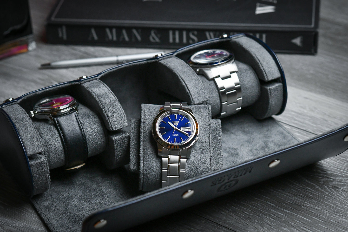 Close-up of luxury watches secured inside the Midnight Blue 3 watch roll with soft gray suede cushions