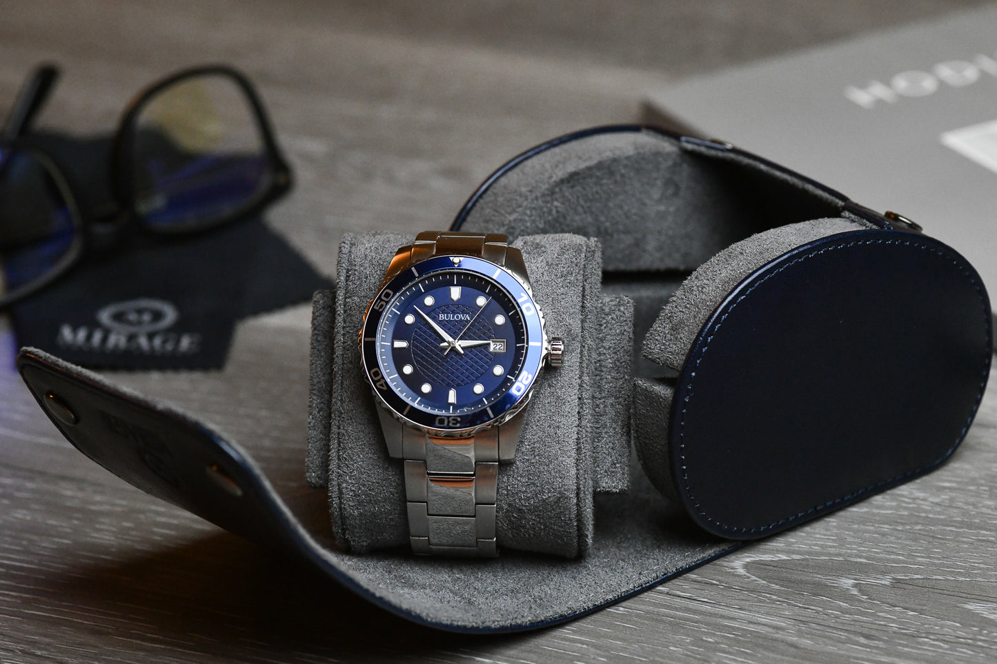 Close-up of a luxury watch secured inside the Mirage Luxury Travel Midnight Blue vegan leather 1 watch roll with plush blue suede lining and signature sliding cushion.