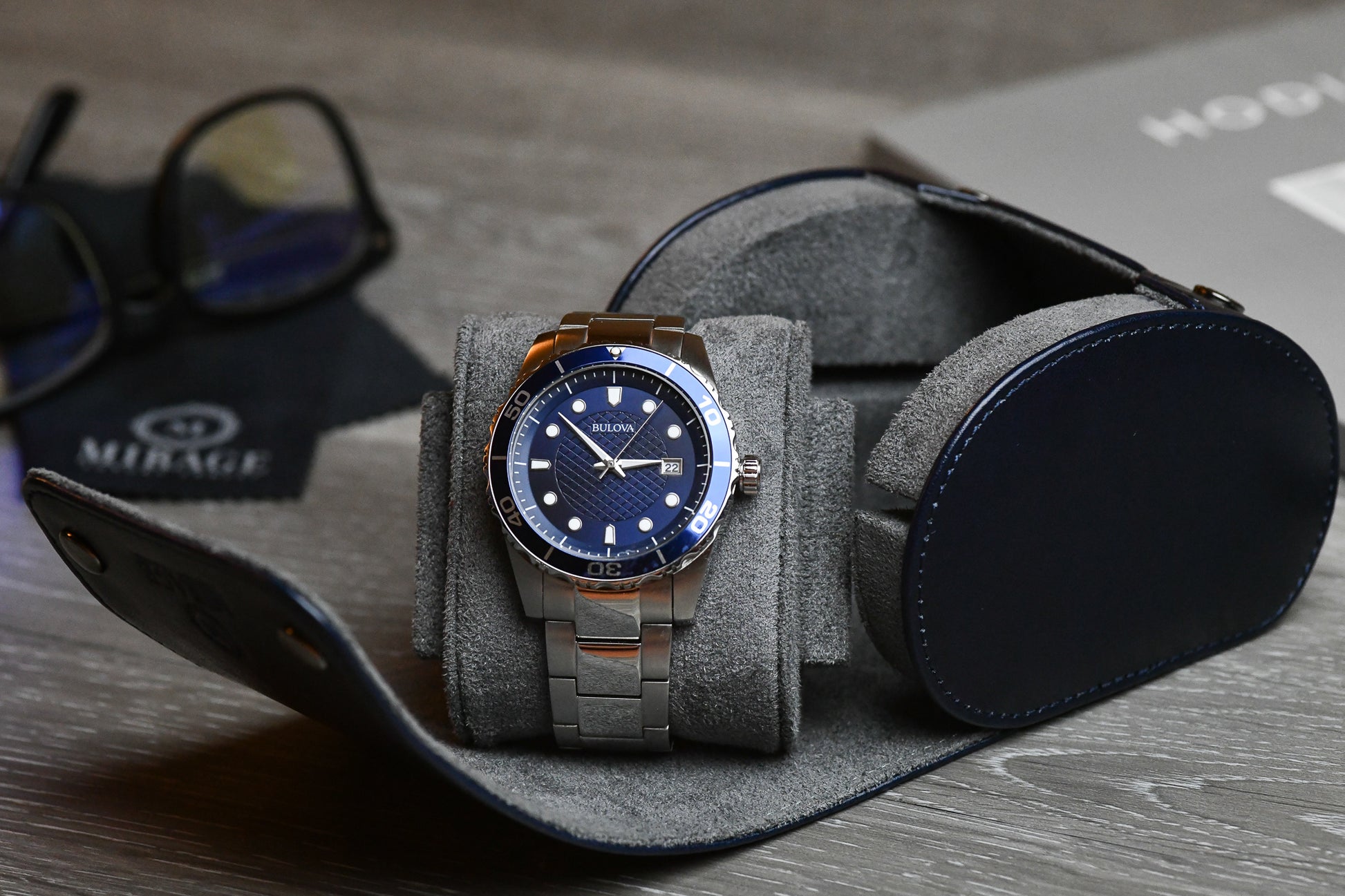 Close-up of a luxury watch secured inside the Mirage Luxury Travel Midnight Blue vegan leather 1 watch roll with plush blue suede lining and signature sliding cushion.