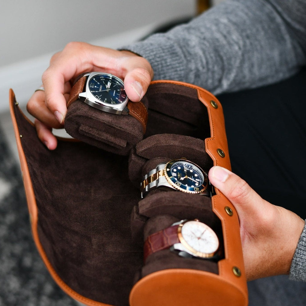 Watch collector organizing luxury watches inside the Mirage Luxury Travel Tawny Brown leather watch roll.