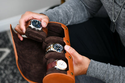 Watch collector organizing luxury watches inside the Mirage Luxury Travel Tawny Brown leather watch roll.