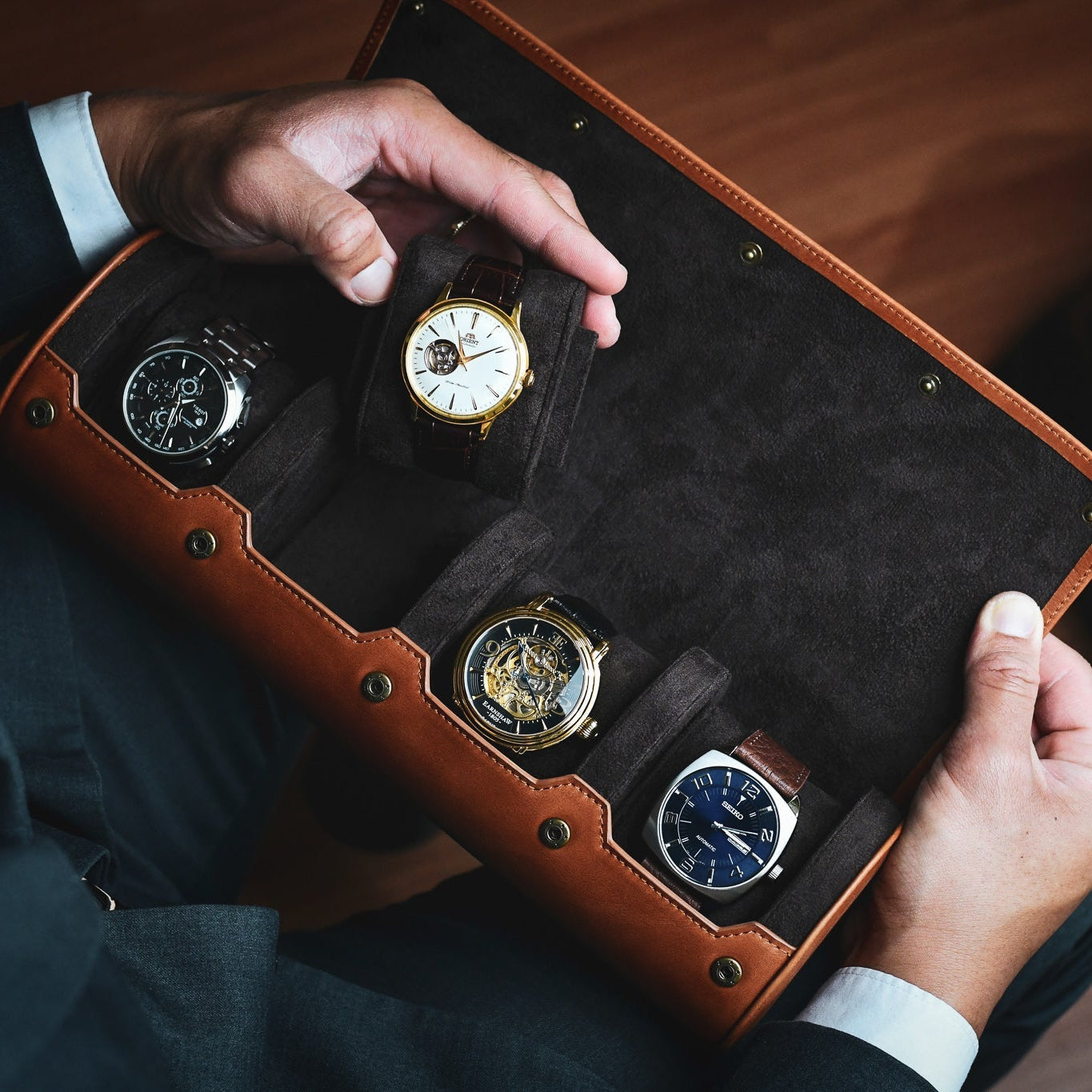 Collector holding Mirage Luxury Travel full-grain leather 4 watch roll travel case.