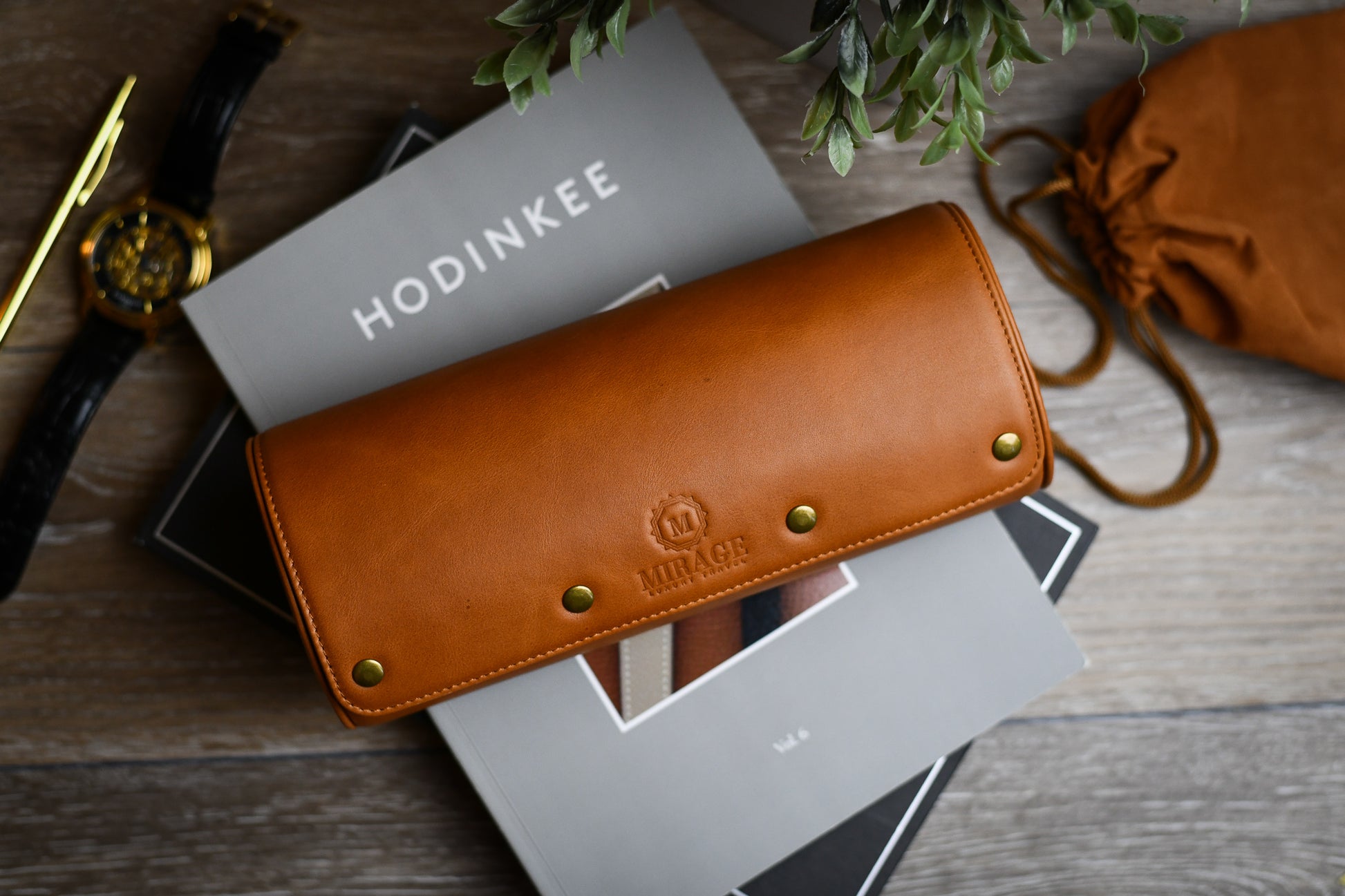 Tawny Brown full-grain leather watch roll displayed on books for elegant home watch storage and organization.