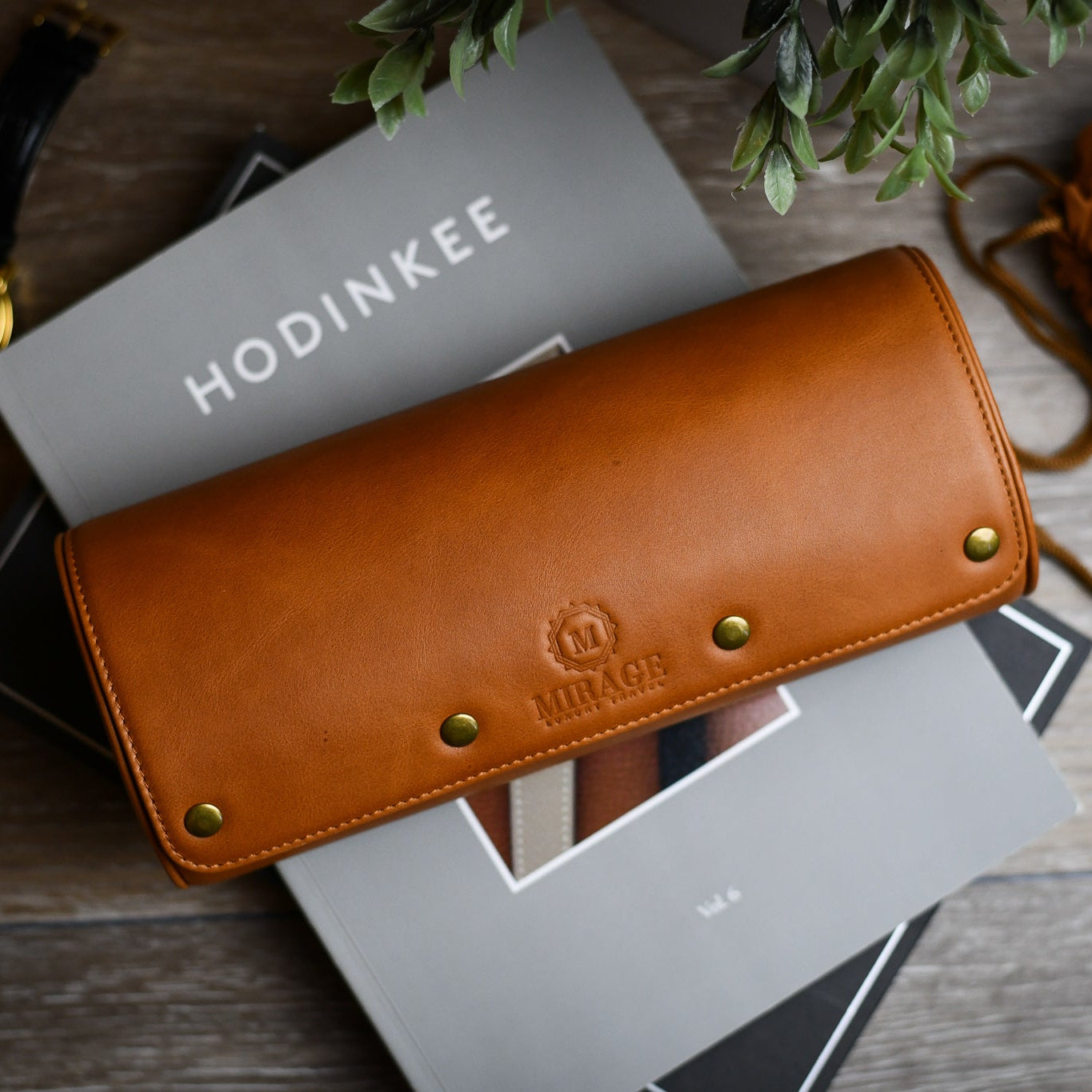 Tawny Brown full-grain leather watch roll displayed on books for elegant home watch storage and organization.