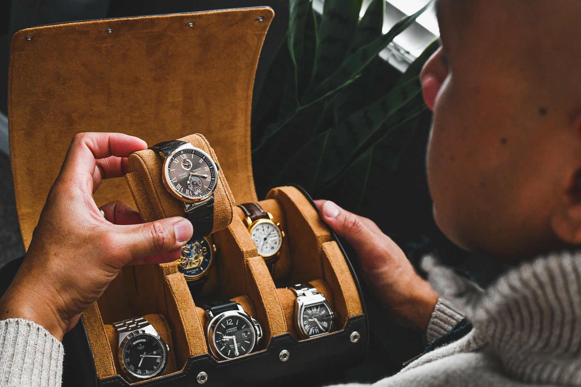 Watch collector organizing luxury watches inside an Espresso Brown premium vegan leather 6 watch roll