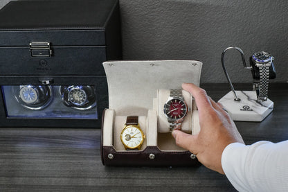 Collector placing luxury watches inside the Espresso Brown vegan leather watch storage case with ivory white suede.