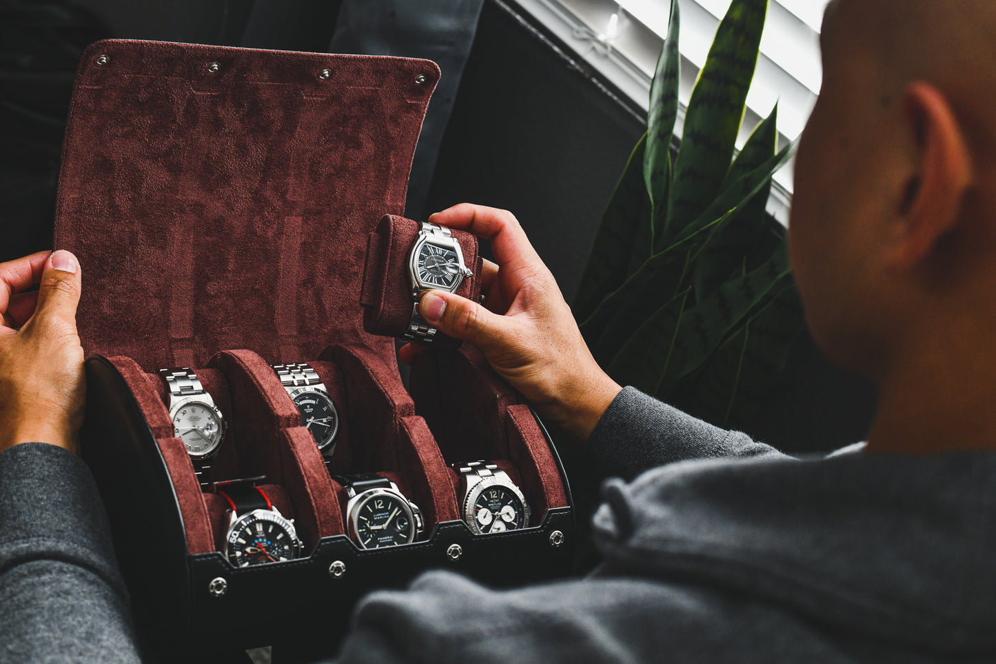 Watch collector organizing luxury watches inside the Jade Black premium vegan leather 6 watch roll