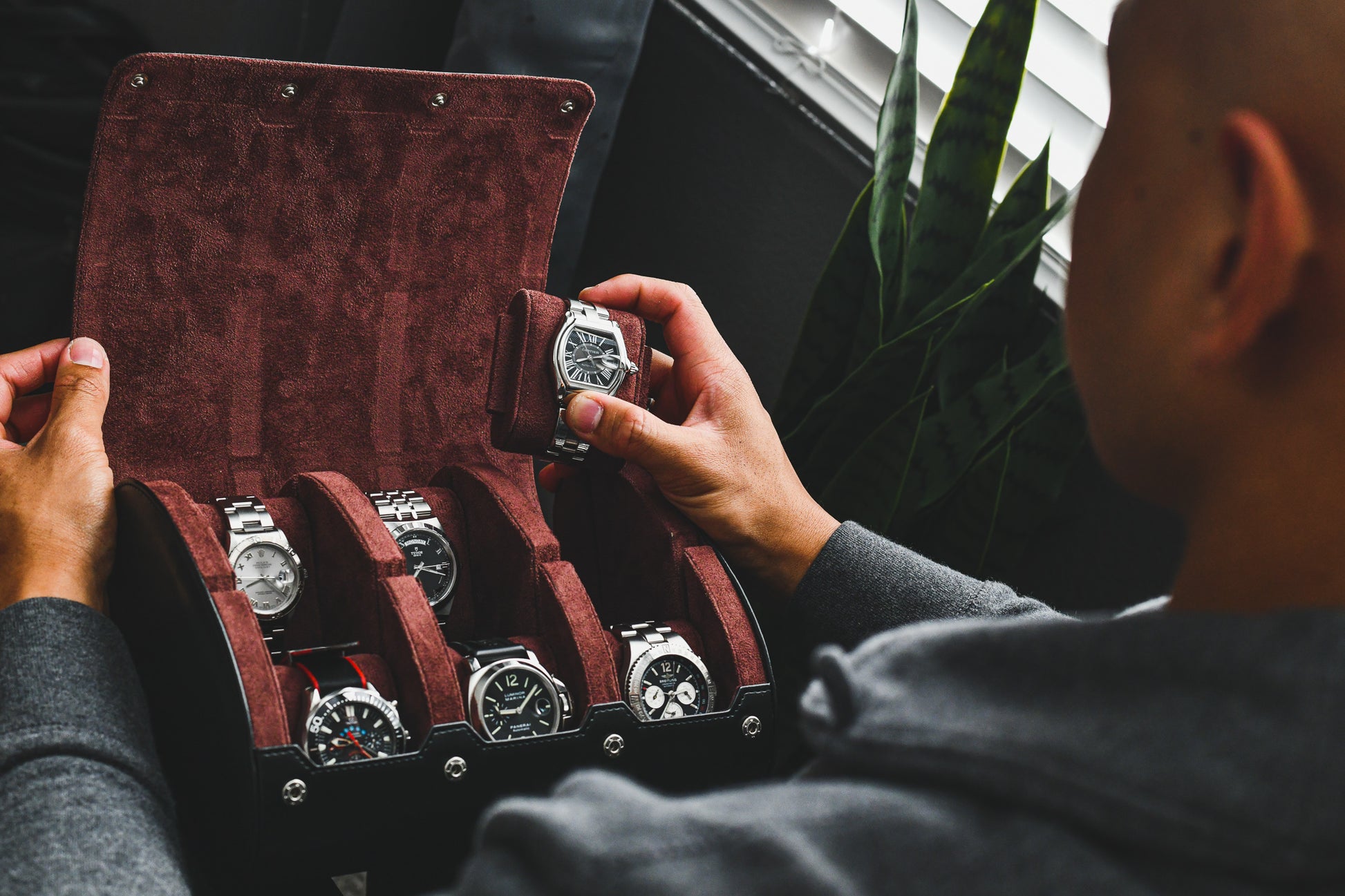 Watch collector organizing luxury watches inside the Jade Black premium vegan leather 6 watch roll