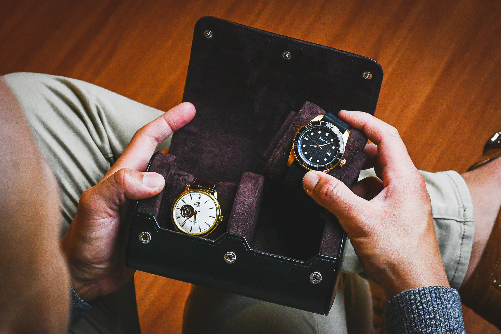 Watch enthusiast organizing two luxury watches inside the Jade Black vegan leather watch storage case.