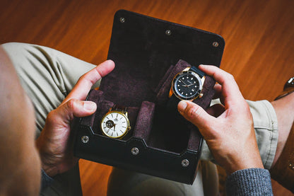 Watch enthusiast organizing two luxury watches inside the Jade Black vegan leather watch storage case.