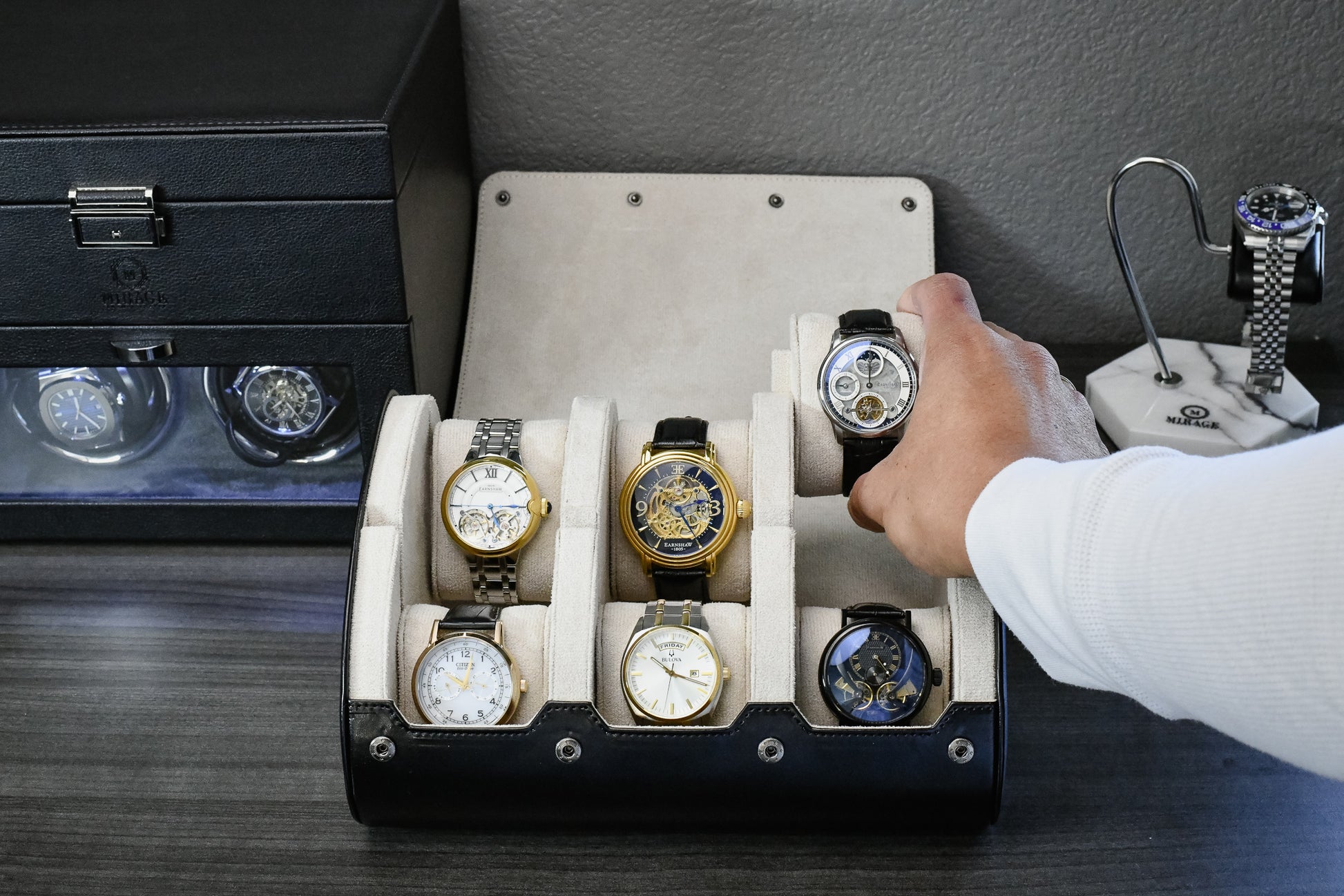 Watch collector organizing luxury watches inside the Jade Black and ivory white premium vegan leather 6 watch roll