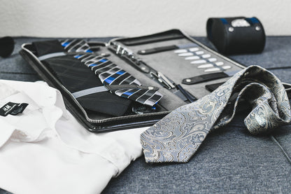 Graphite Black premium vegan leather tie travel case displayed with neckties and business attire, ideal for professionals and frequent travelers.