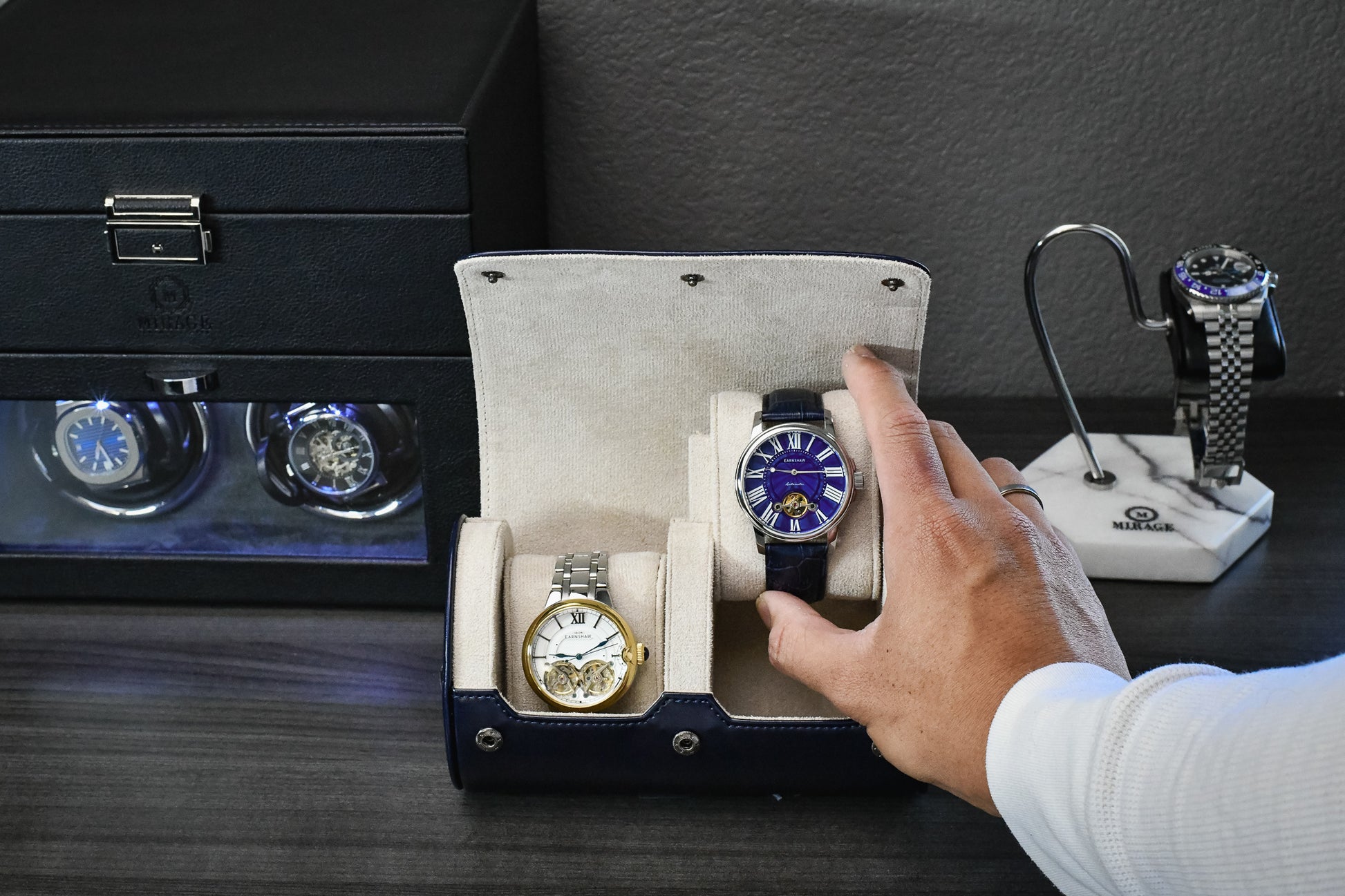 Watch collector placing a luxury timepiece into the Midnight Blue vegan leather 2 watch organizer.