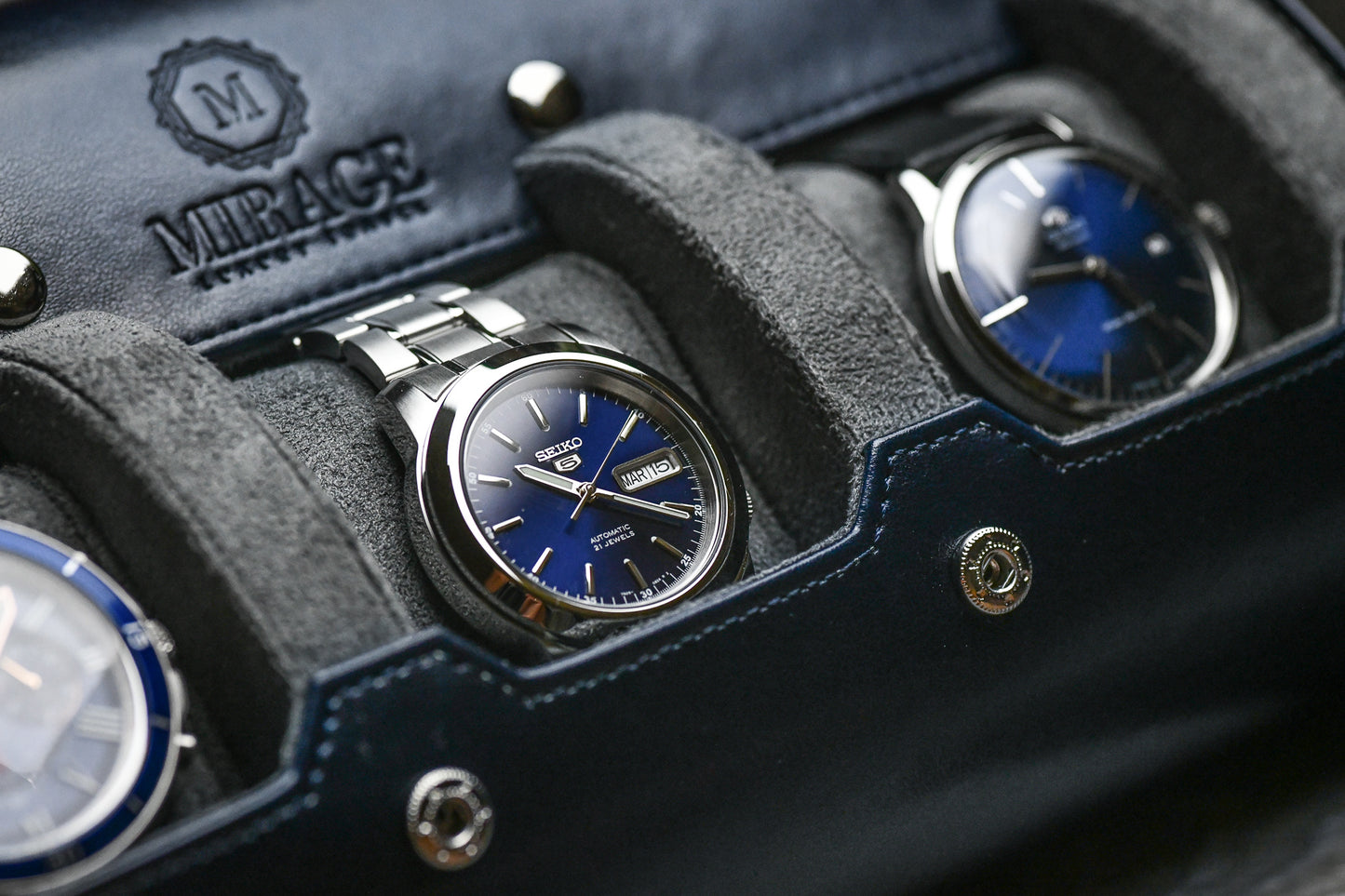 Detailed view of luxury watch resting on premium gray suede sliding cushion inside Midnight Blue watch roll
