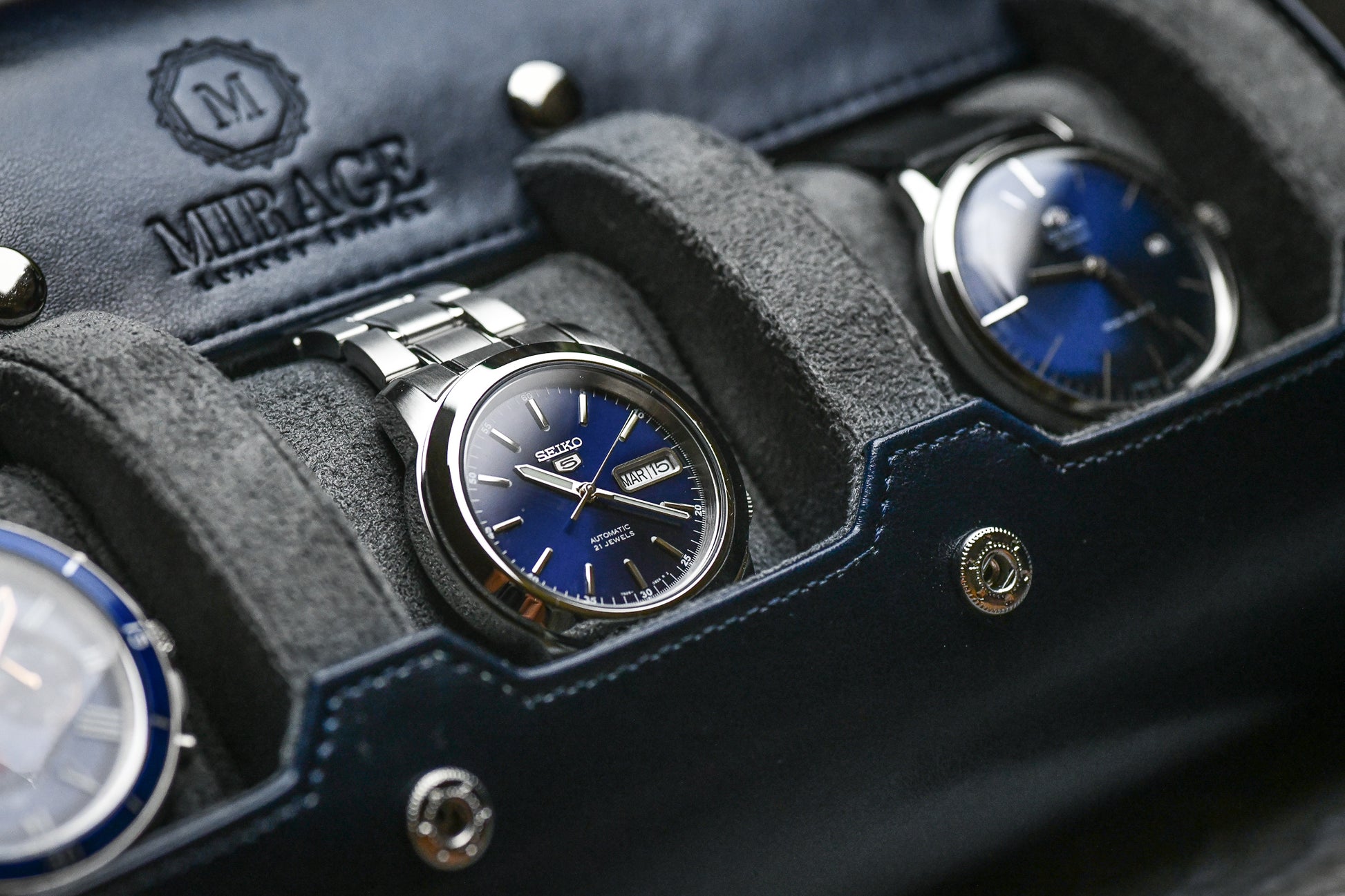 Detailed view of luxury watch resting on premium gray suede sliding cushion inside Midnight Blue watch roll