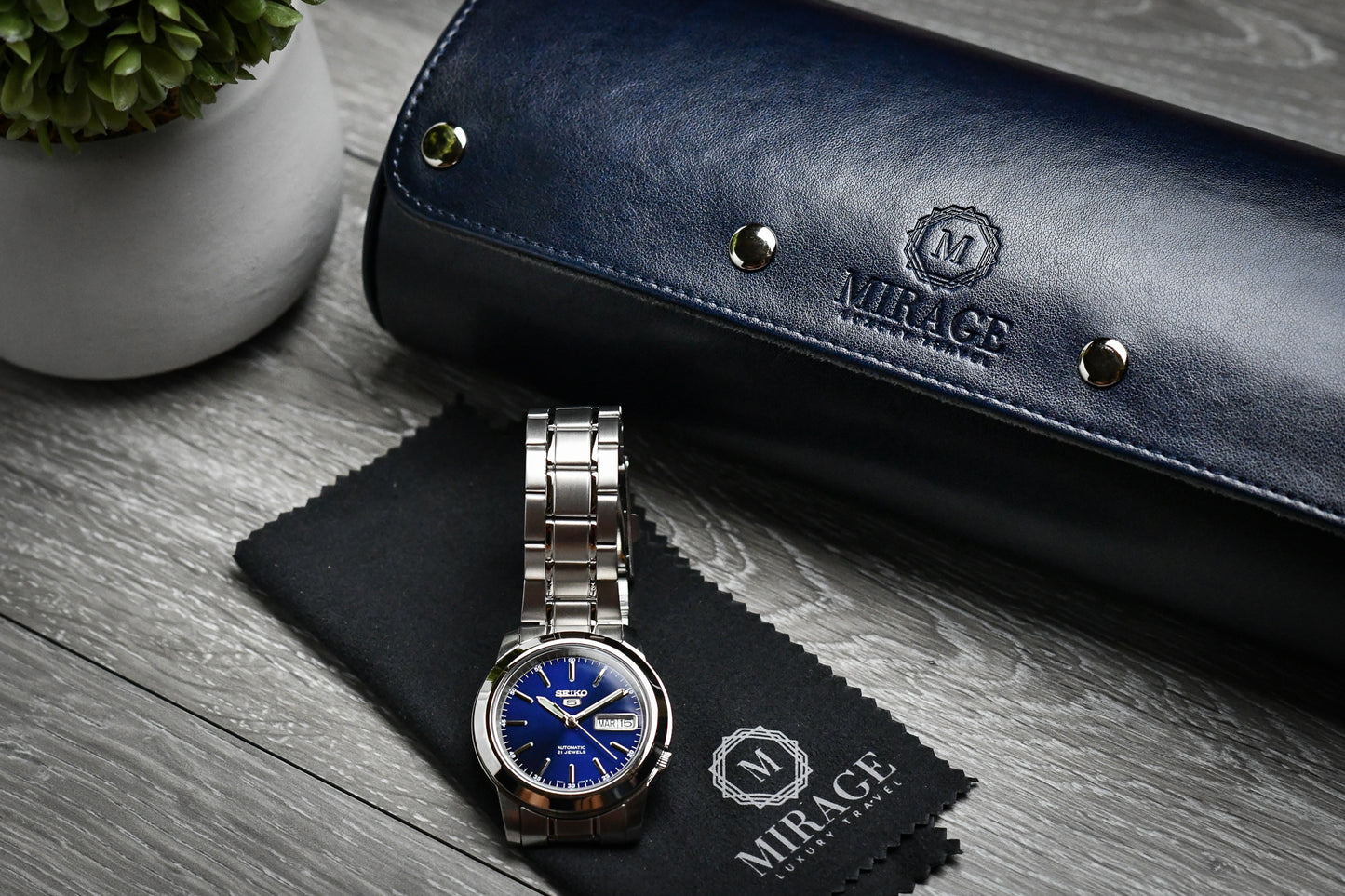 Closed Midnight Blue premium vegan leather 3 watch roll displayed beside luxury watch accessories