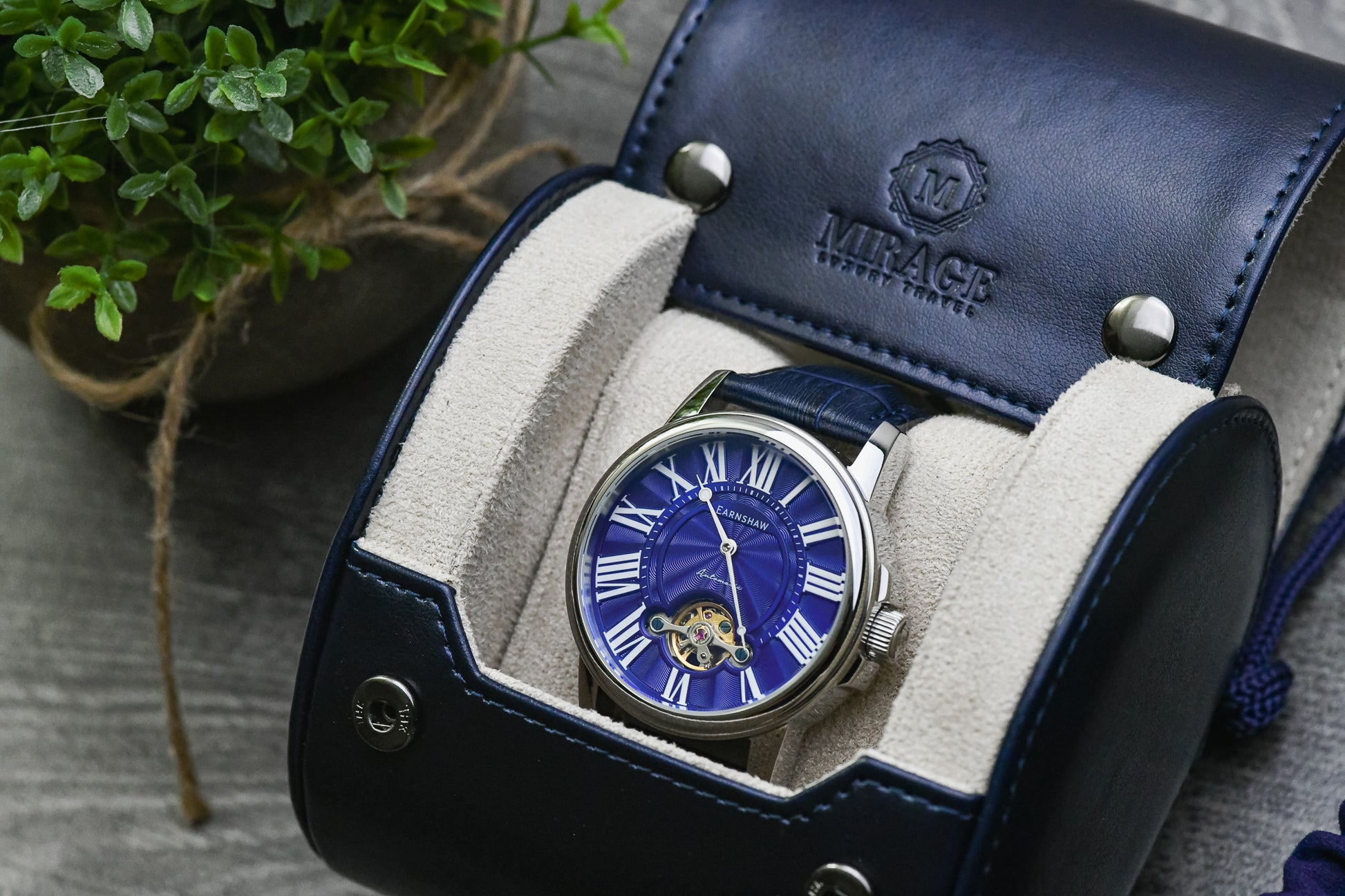 Open Midnight Blue vegan leather watch roll featuring a luxury watch secured on a plush blue suede sliding cushion.