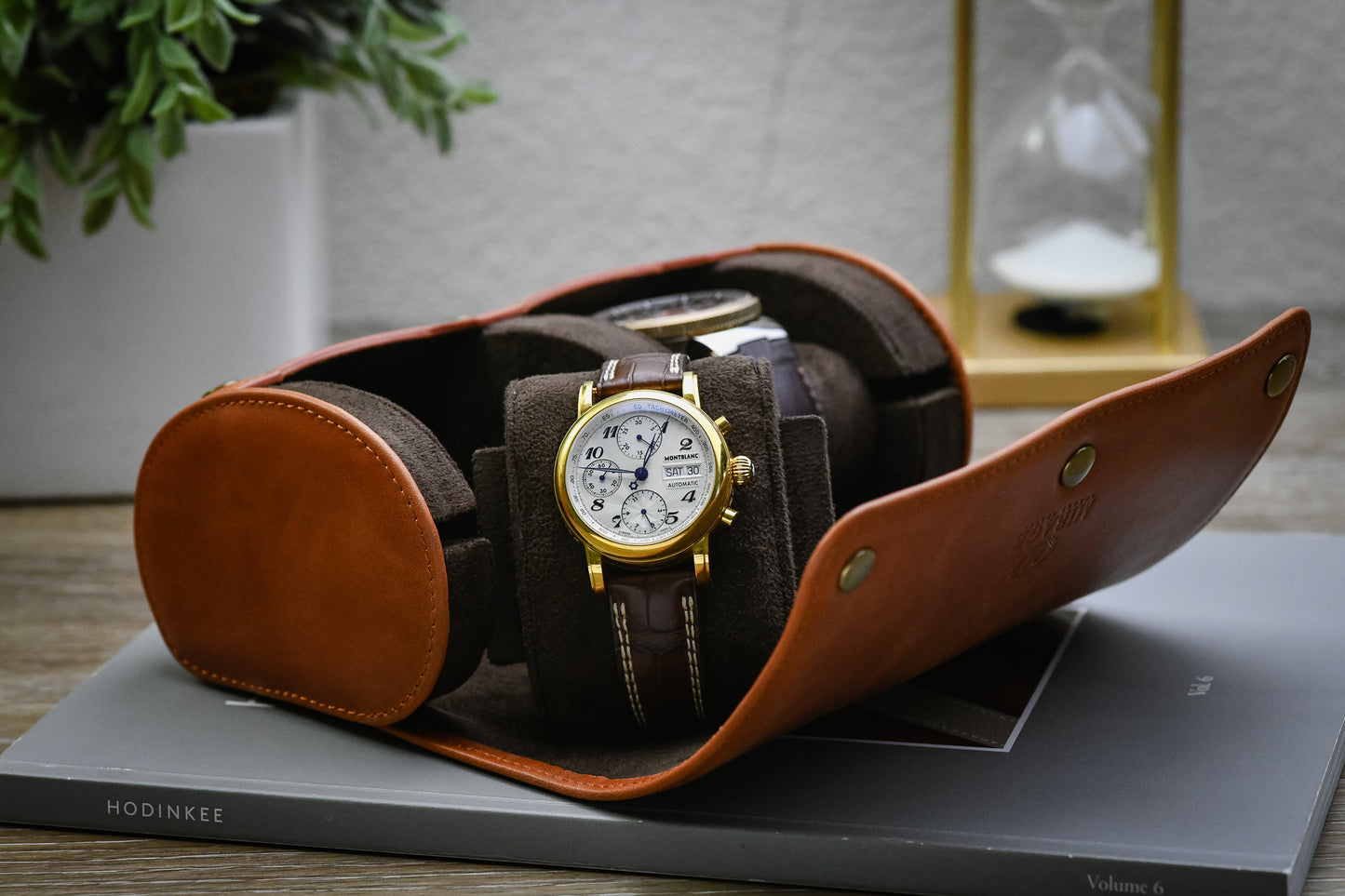 Open Tawny Brown full-grain leather watch roll with two luxury watches secured on plush suede cushions.