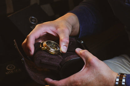 Collector opening the Mirage Luxury Travel Signature Collection Jade Black premium vegan leather 1-watch roll, revealing the premium suede-lined interior and secure sliding watch cushion.