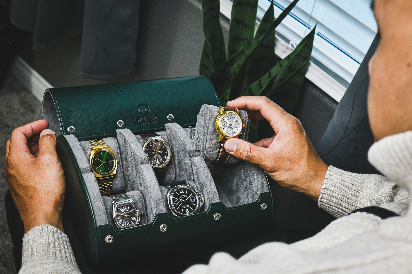 Watch collector organizing luxury watches inside a Royal Green 6 watch roll with premium suede interior and sliding watch cushions