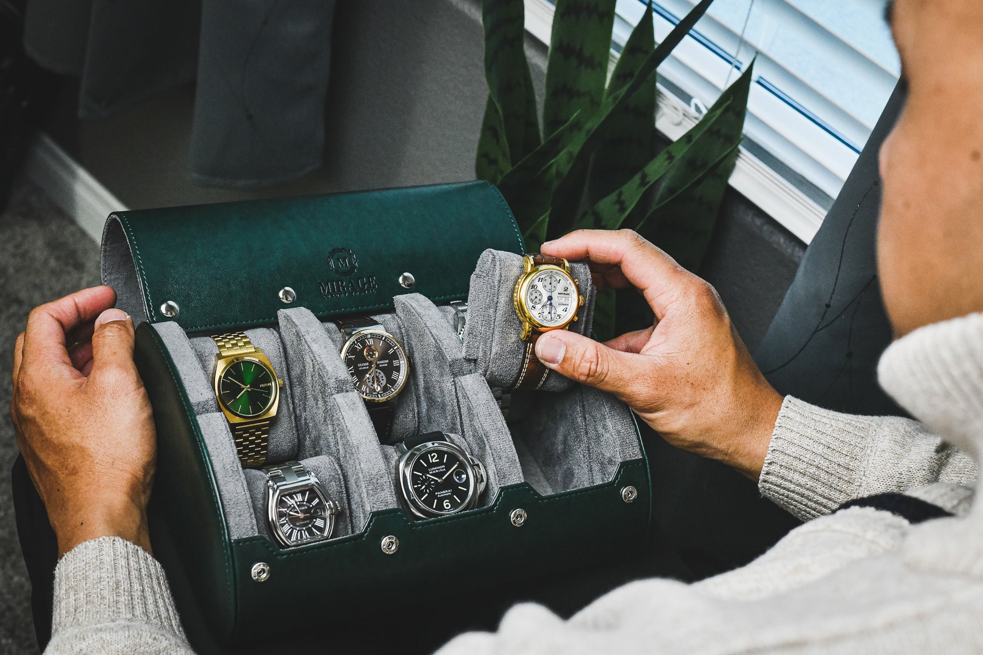 Watch collector organizing luxury watches inside a Royal Green 6 watch roll with premium suede interior and sliding watch cushions