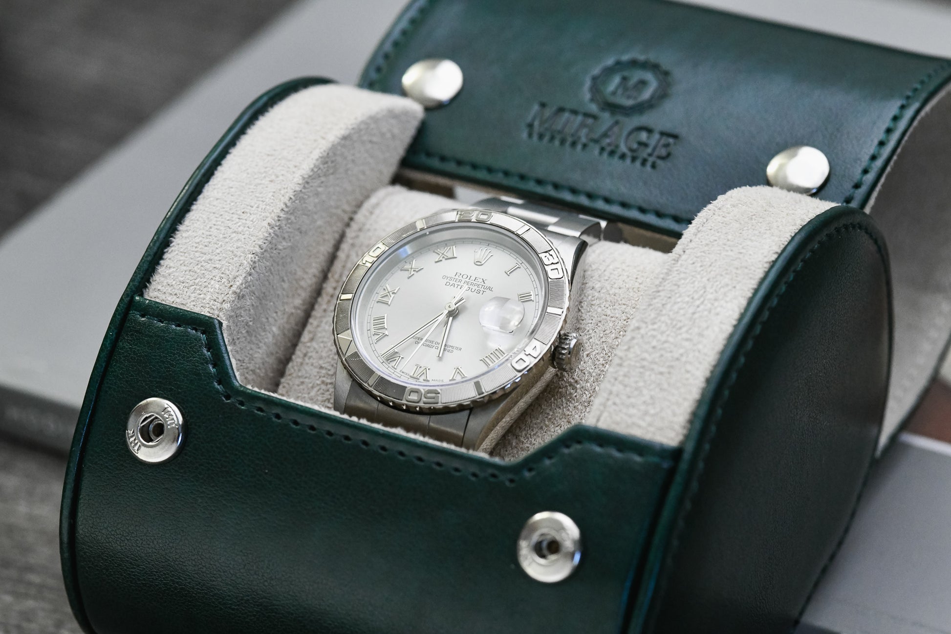 Front view of the Royal Green vegan leather 1 watch roll showcasing its ivory white interior and secure watch cushion.