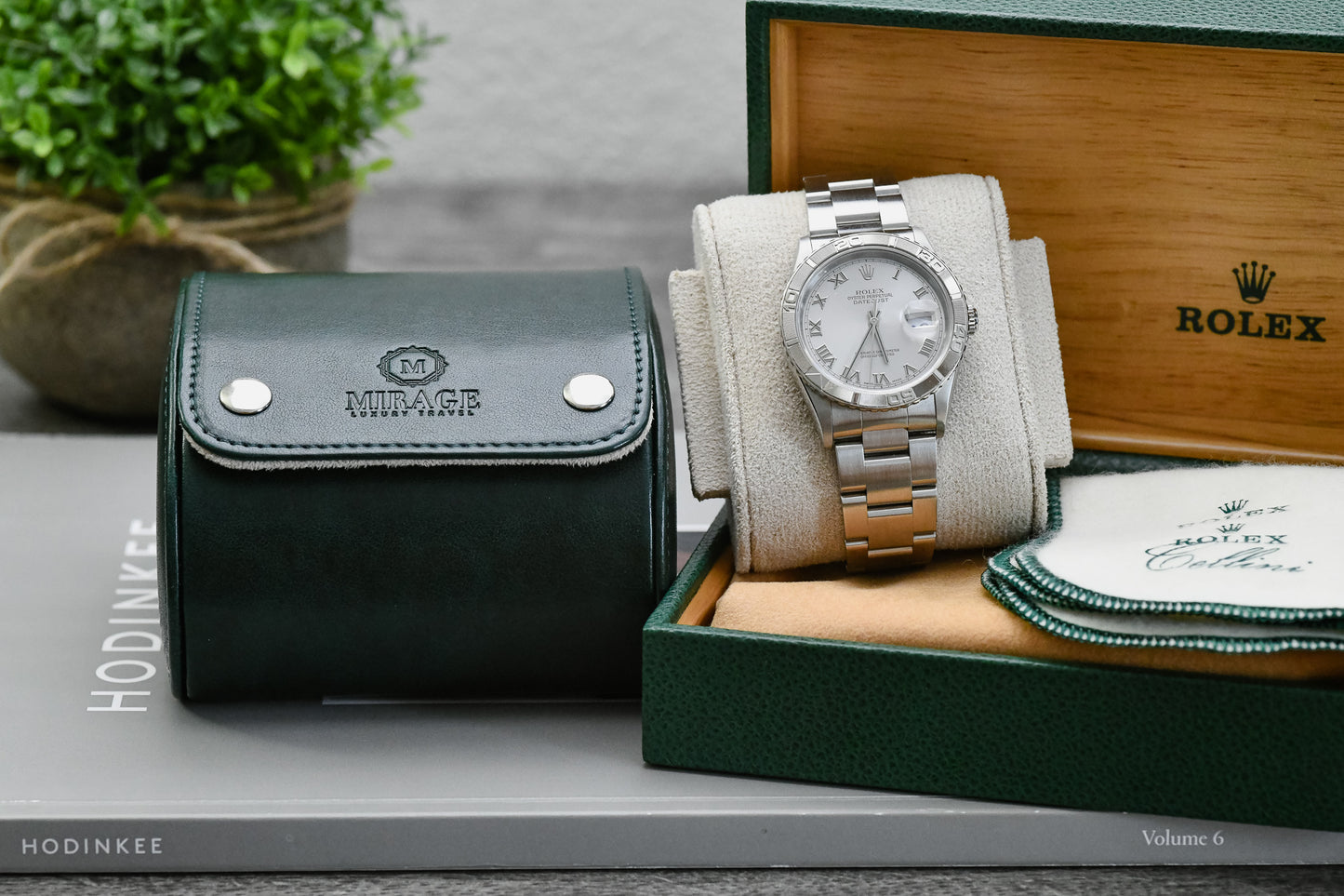 Royal Green vegan leather watch roll displayed with Mirage Luxury Travel gift box and luxury watch.