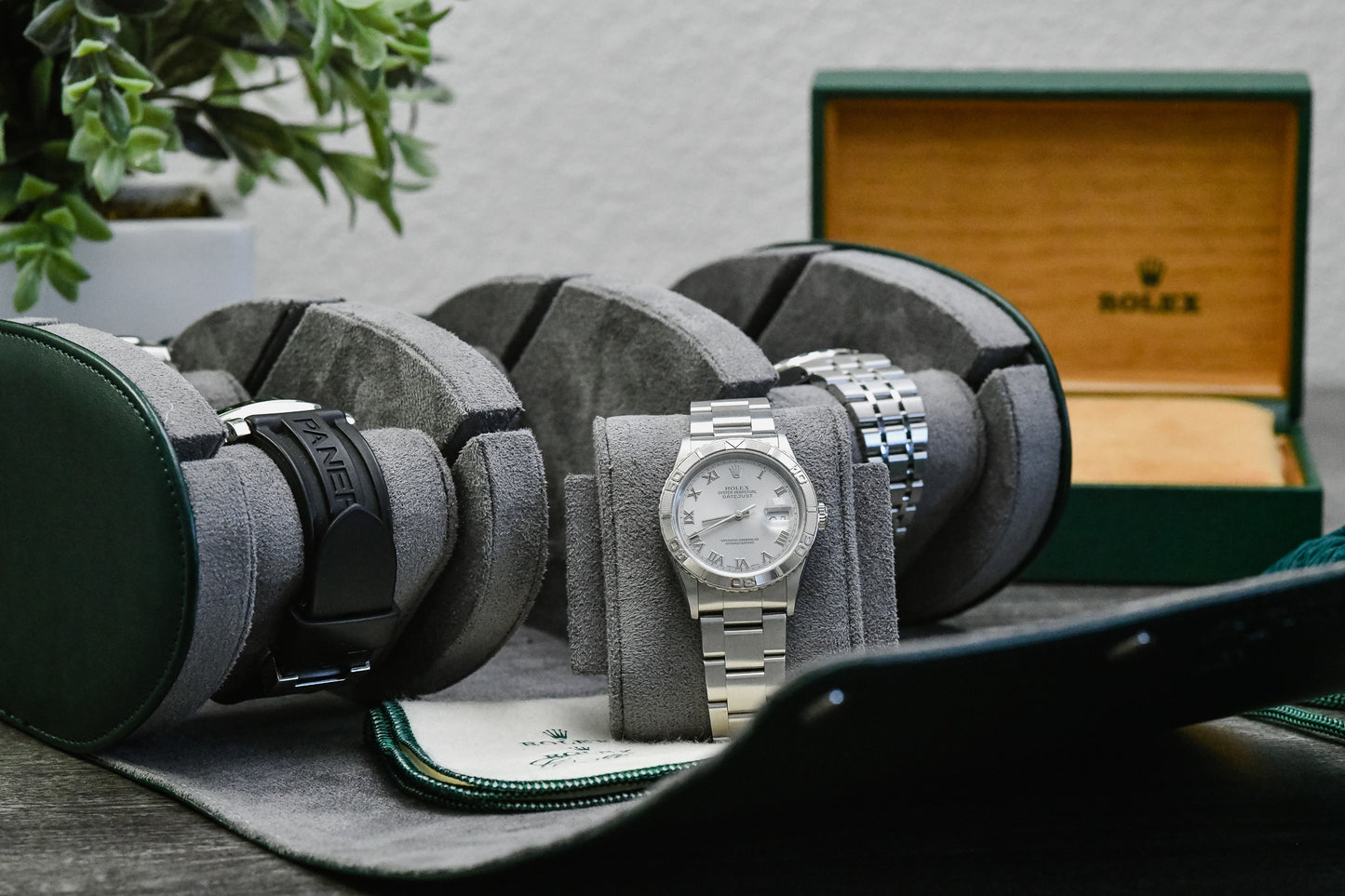Royal Green luxury watch roll travel case beside camera gear for collectors, business travel, and everyday watch storage