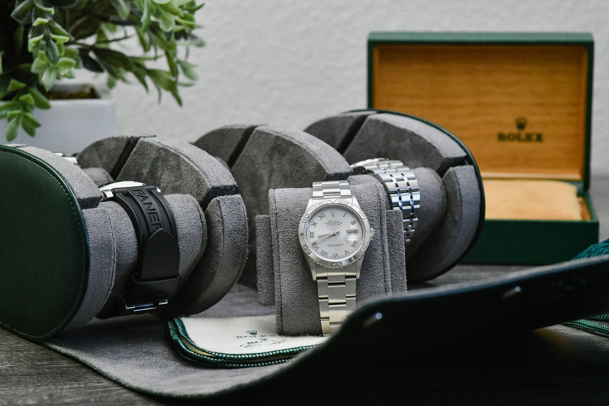Royal Green luxury watch roll travel case beside camera gear for collectors, business travel, and everyday watch storage