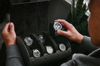 Watch collector organizing luxury watches inside a Slate Gray 6 watch roll with premium suede interior and sliding watch cushions