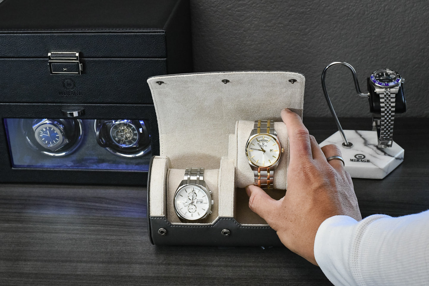 Watch collector placing a luxury watch inside the Slate Gray vegan leather 2 watch organizer with ivory white suede lining.