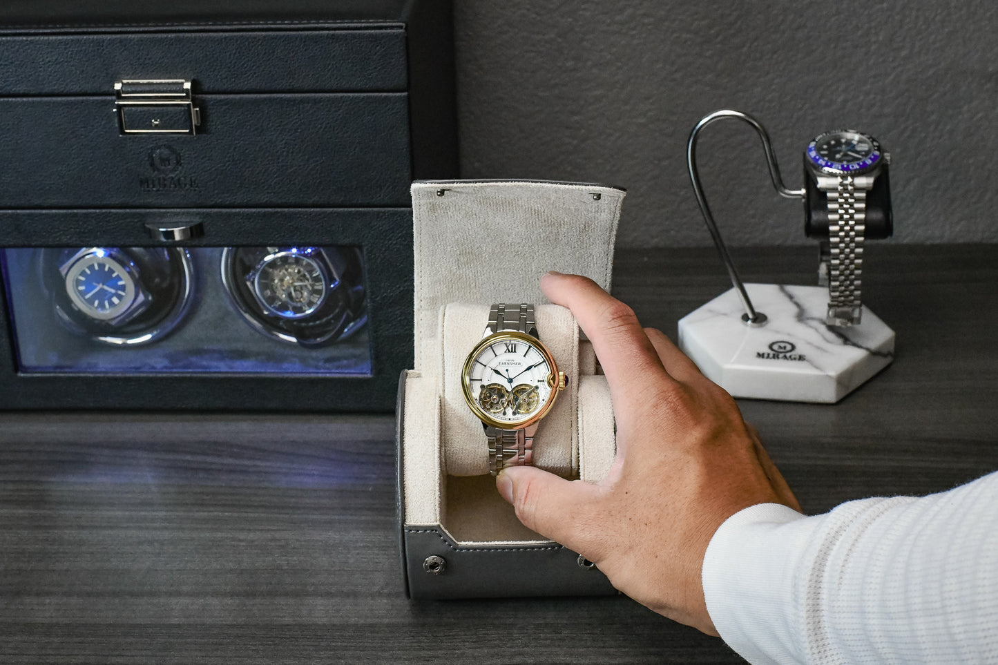 Collector placing a luxury watch into the Slate Gray vegan leather watch roll with ivory white suede interior.
