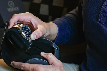 Collector placing a luxury watch into the Slate Gray vegan leather travel watch case.