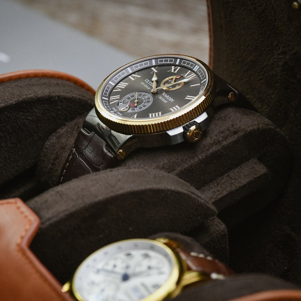 Close-up of luxury watches resting on Mirage signature sliding cushions inside a Tawny Brown leather watch roll.