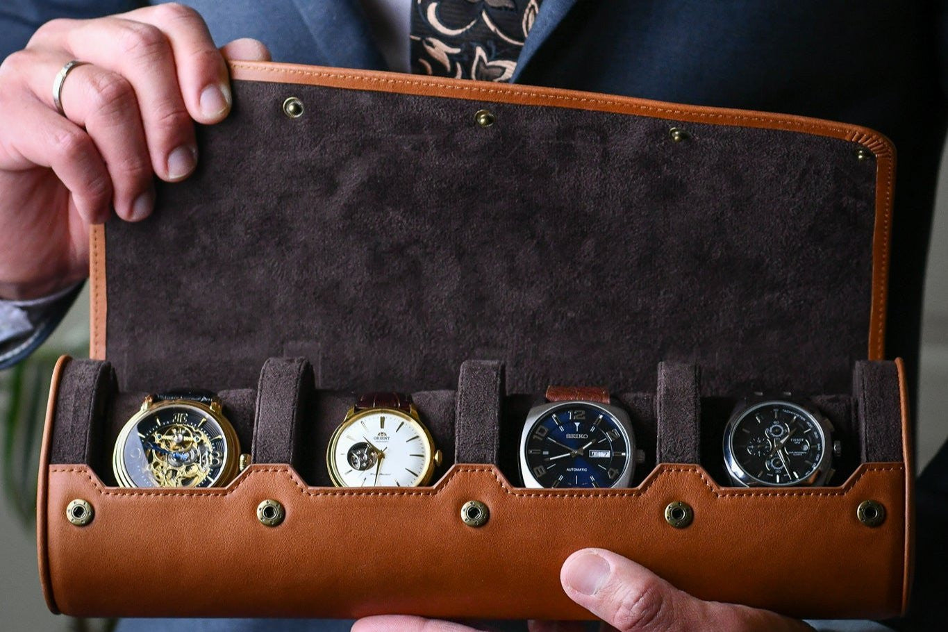 Soft suede-lined interior with sliding cushions protecting four luxury watches.