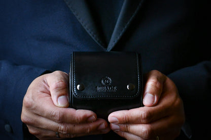 Collector holding the Super Black vegan leather 1 watch roll during everyday travel.