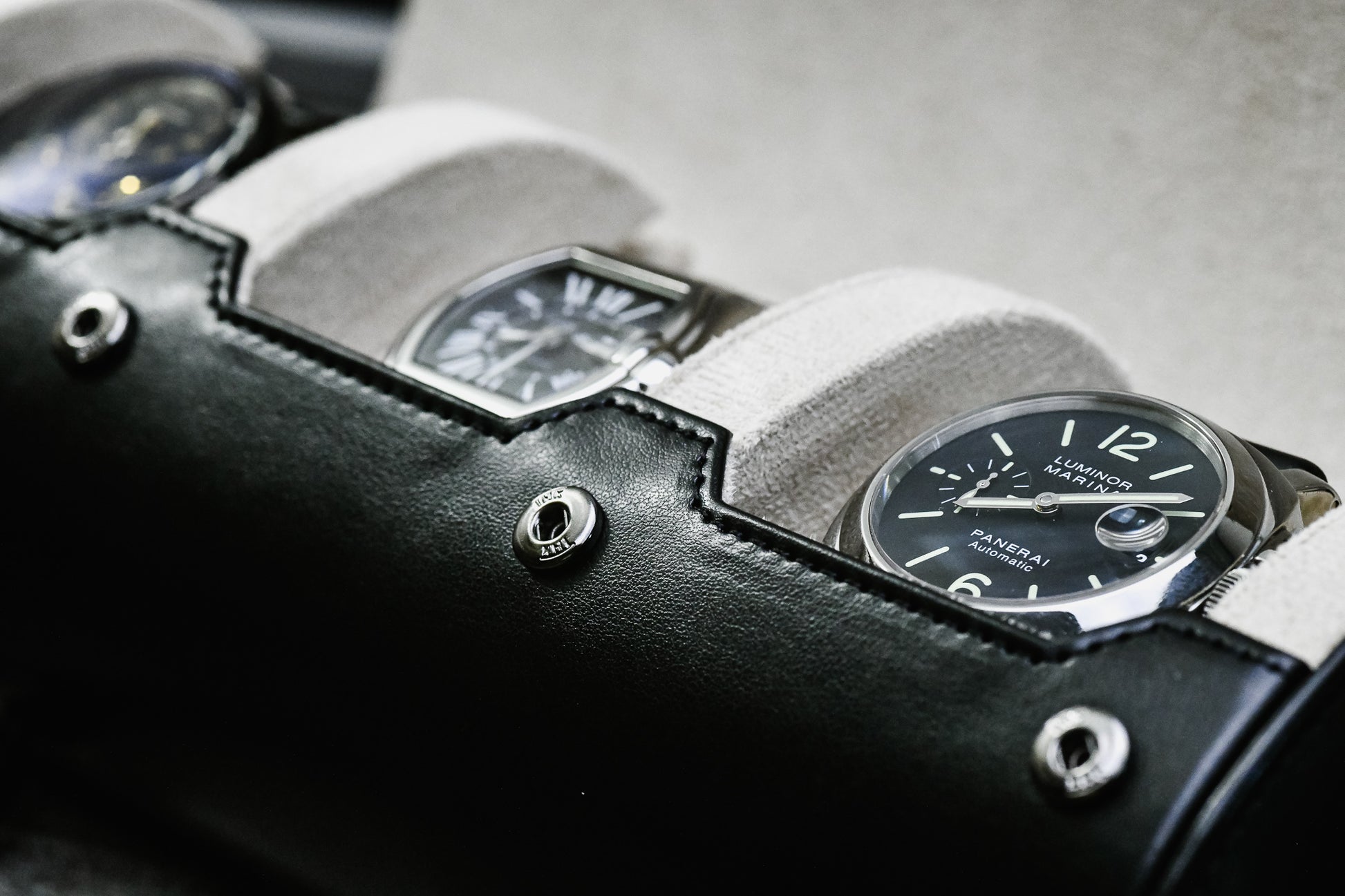 Close-up of luxury watch secured inside Jade Black 3 watch roll with sliding cushions and ivory white suede lining