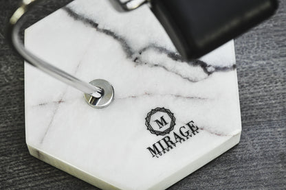 Close-up of the genuine White Lilac Marble base featuring natural stone veining and the Mirage Luxury Travel logo with premium craftsmanship.